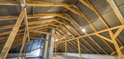 Attic of a building with wooden beams of a roof structure.